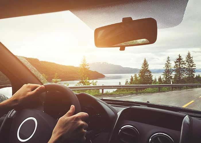 inside of a car looking through the windshield over a lake
